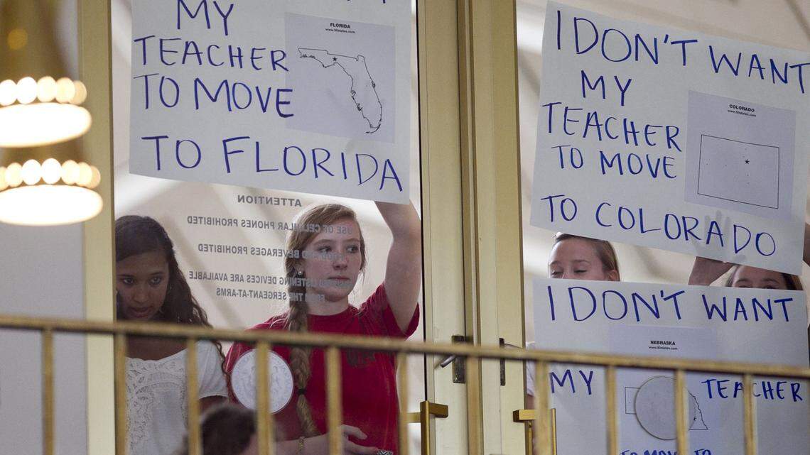 Some of the nearly fifty student protestors from Carrboro, N.C. hold their protest signs calling for better teacher pay against the glass of the State House Chamber’s second floor during their afternoon session on Wednesday, May 28, 2014 in Raleigh, N.C. House speaker Thom Tillis said the sings were against House rules but allowed them because they were students and he agreed with their message.