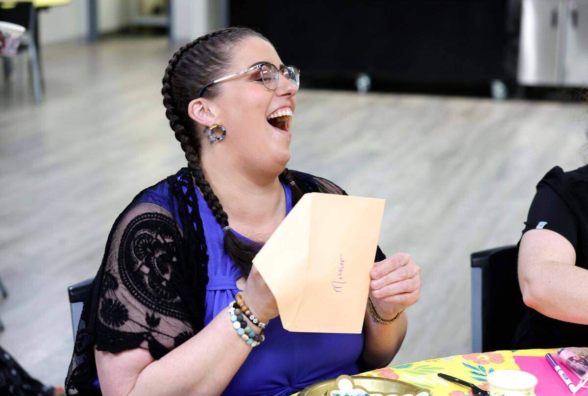 Lela Brantley opens her card during a Mother’s Day tea at Healing Transitions in Raleigh, N.C., Saturday, May 10, 2025. Healing Transitions is a place for recovery of all addictions. The tea was organized by Brantley and participant Jill Hurt, both of whom are recovering from alcohol addiction.