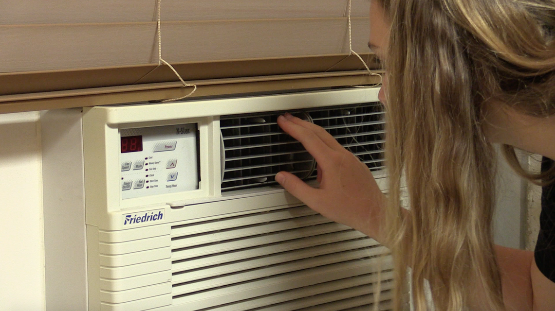 Emili Potts examines the window AC unit of her room in Craige dormitory at The University of North Carolina.