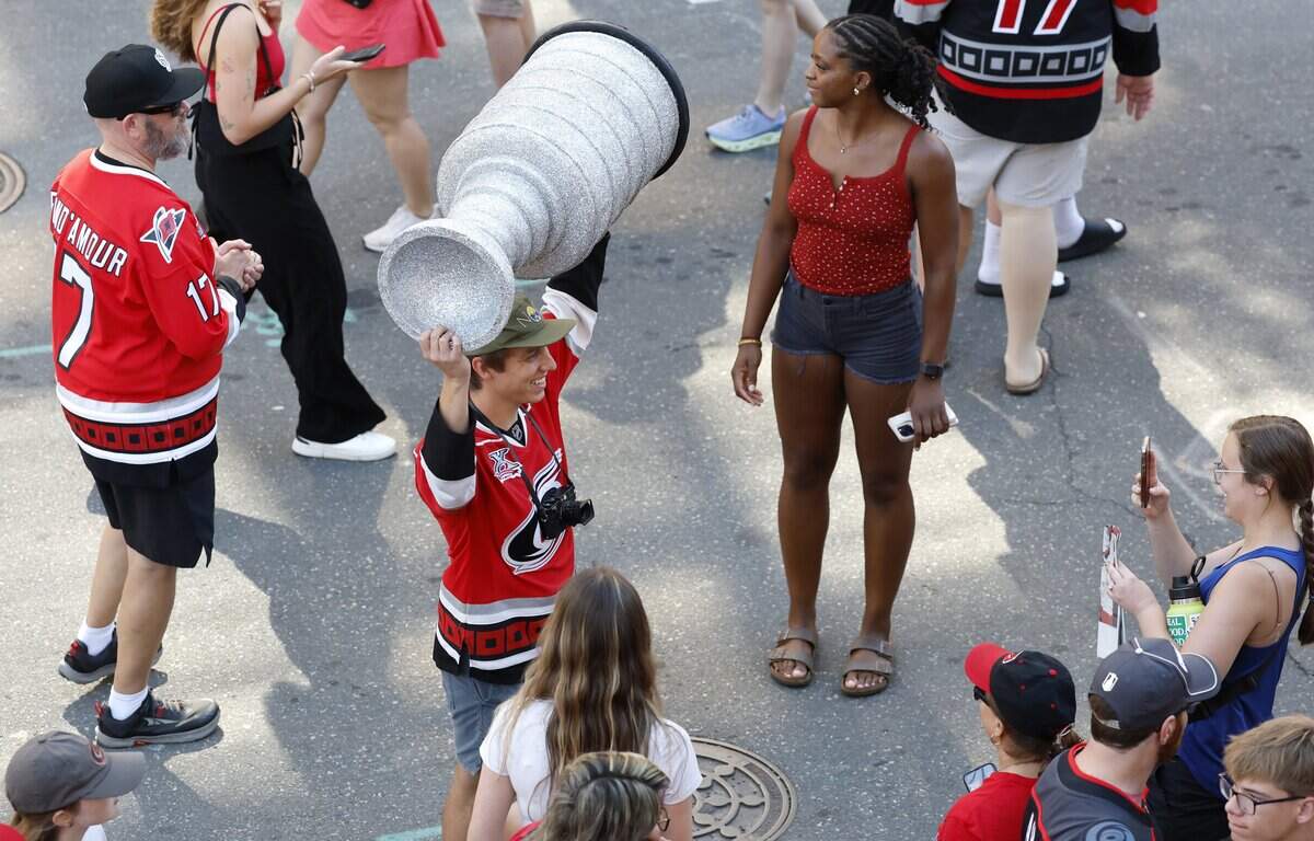 Fans poses with a replica of the Stanley Cup before a parade and rally for the Carolina Hurricanes in downtown Raleigh Saturday, June 20, 2026.