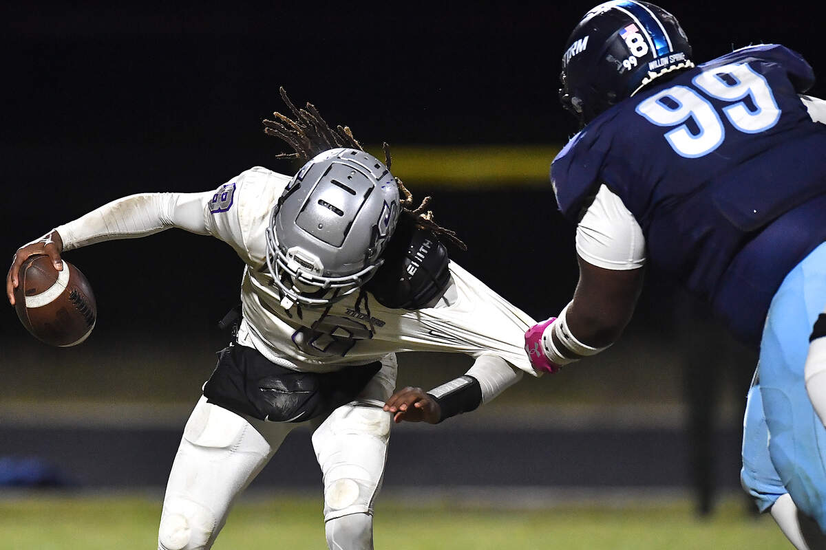 Willow Spring defensive tackle Javeion Matthews (99) grapples and sacks South Garner quarterback Chase Hardy (8) during the second half. The Willow Spring Storm and the South Garner Titans met in a football game in Fuquay-Varina. N.C. on October 18, 2024.