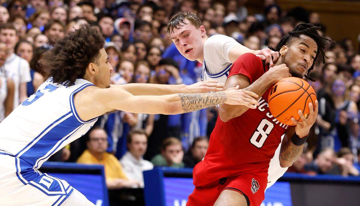 N.C. State’s Jayden Taylor (8) keeps the ball from Duke’s Tyrese Proctor (5) and Cooper Flagg (2) during the first half of Duke’s game against N.C. State at Cameron Indoor Stadium in Durham, N.C., Monday, Jan. 27, 2025.