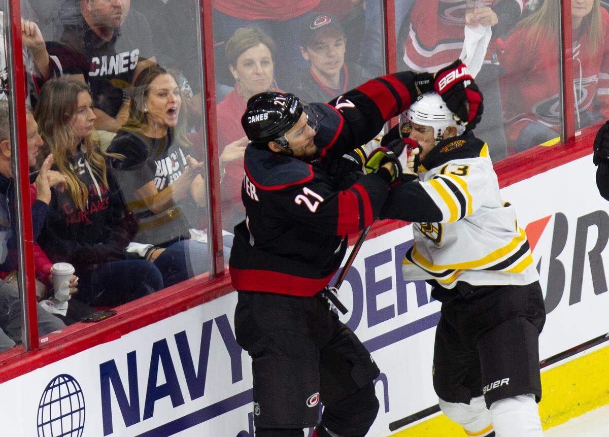 Carolina’s Nino Niederreiter (21) and Boston’s Charlie Coyle (13) tussle on the boards during the first period of Game 3 of the Eastern Conference Finals Tuesday, May 14, 2019 at PNC Arena in Raleigh, NC.