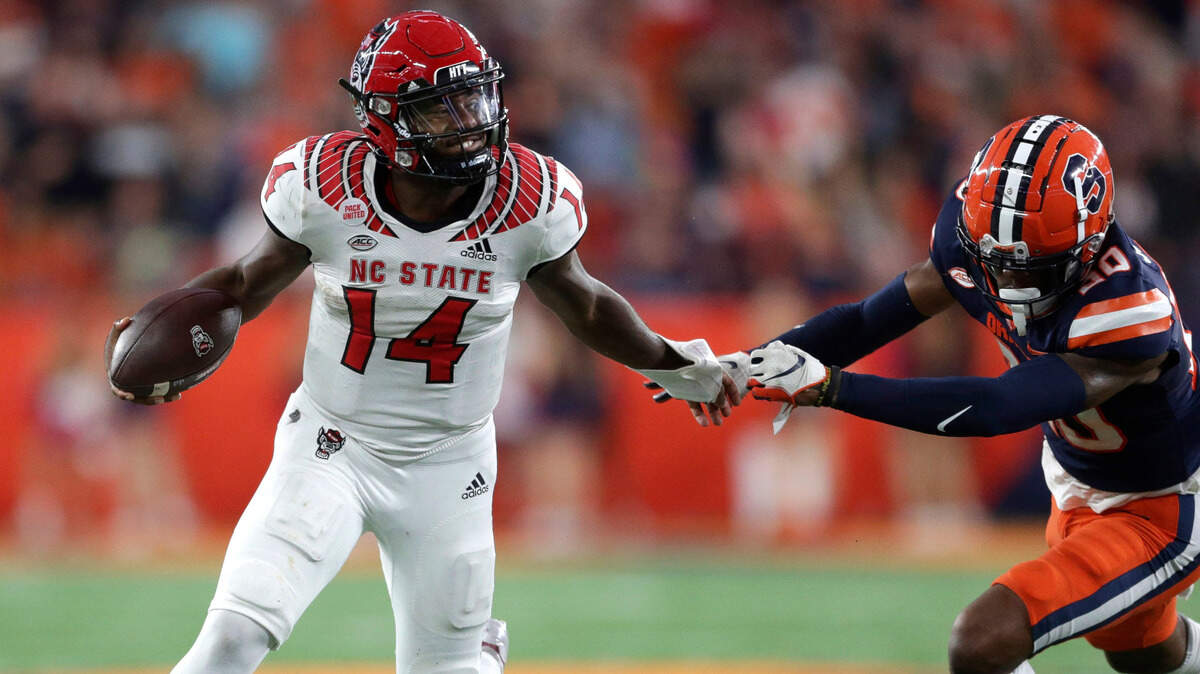 North Carolina State quarterback Jack Chambers (14) escapes a tackle by Syracuse defensive lineman Chase Simmons (30) during the second half of an NCAA college football game Saturday, Oct. 15, 2022, in Syracuse, N.Y.