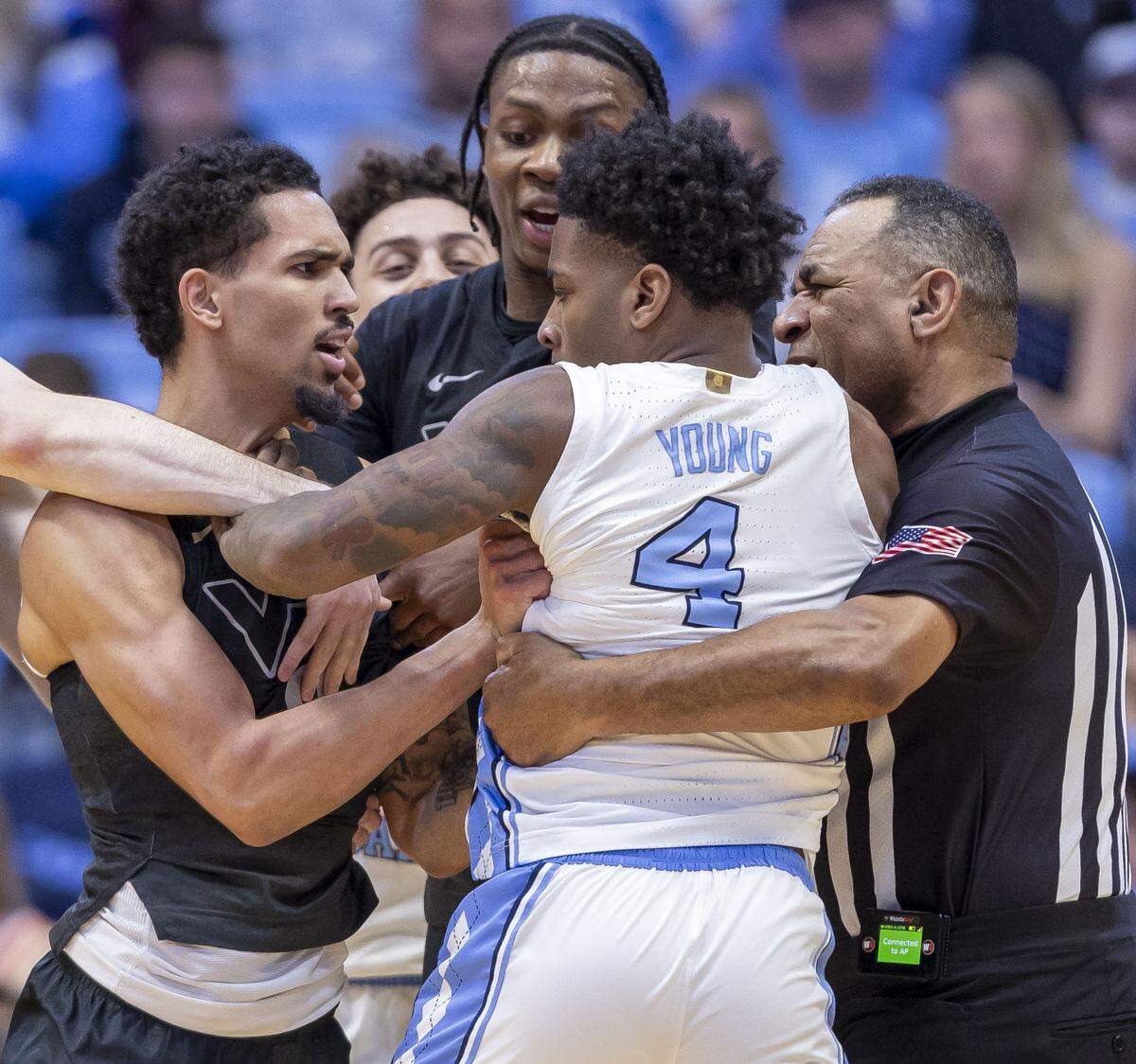 Official Jeffrey Clark works to separate North Carolina guard Jaydon Young (4) and Virginia Tech guard Jailen Bedford (0) after an altercation in the closing minute of play on Saturday, February 28, 2026 at the Smith Center in Chapel Hill, N.C.  Both players received technical fouls.