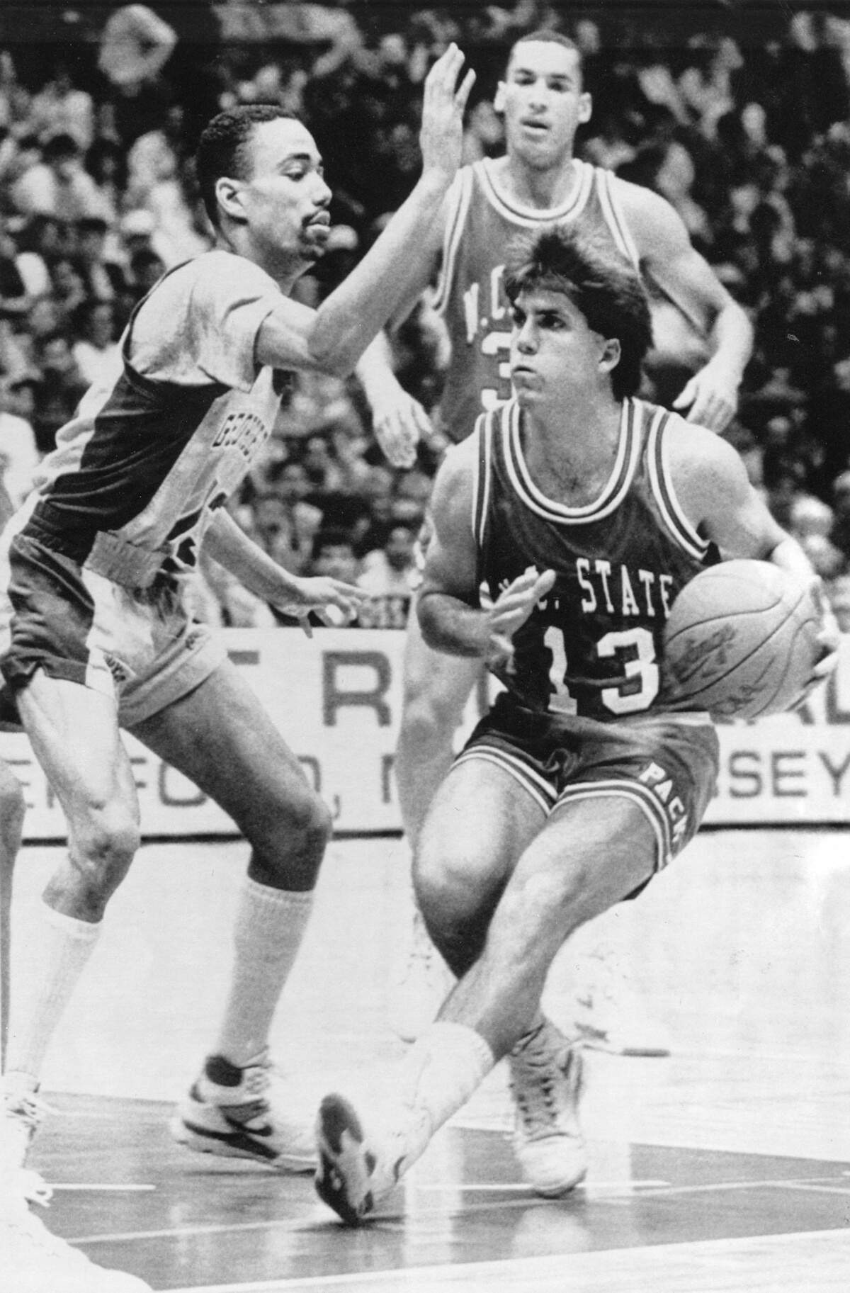 EAST RUTHERFORD, N.J., March 24--SPECIAL FOR RALEIGH NEWS & RECORD--Chris Corchiani (13) of North Carolina State slips by Georgetown defender Charles Smith, left, during NCAA East Regional Semi-Final game in East Rutherford, N.J., on Friday night. (AP LaserPhoto)(Scott Sharpe)89