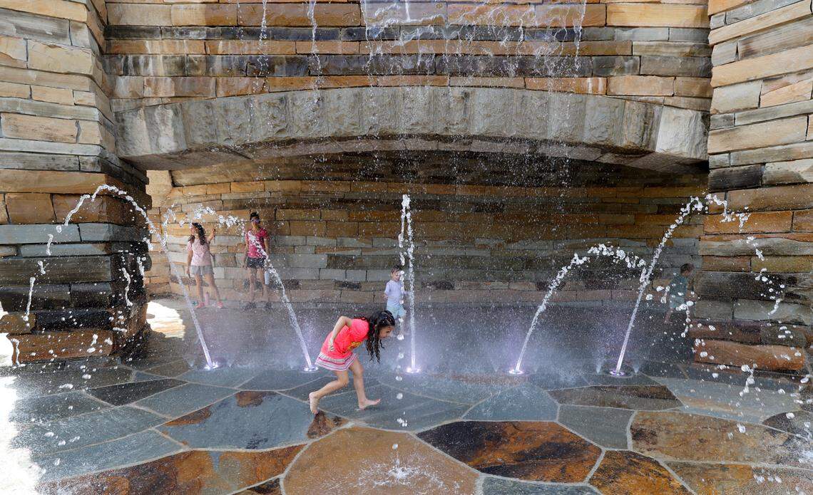Children enjoy a waterfall and fountains at Gipson Play Plaza at Dix Park during a preview day Saturday, May 24, 2025. The park will officially open with a grand opening celebration on June 6th, 7th and 8th.