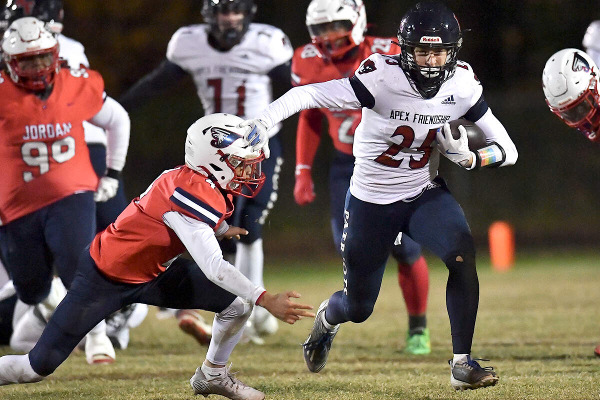Apex Friendship’s Gavin Faulring (25) stiff-arms Jordan’s Ezekiel Stokes (4) and runs for yardage during the first half. The Apex Friendship Patriots and the Durham Jordan Falcons met in the second round of the NCHSAA 4A playoffs in Durham, N.C. on November 22, 2024.