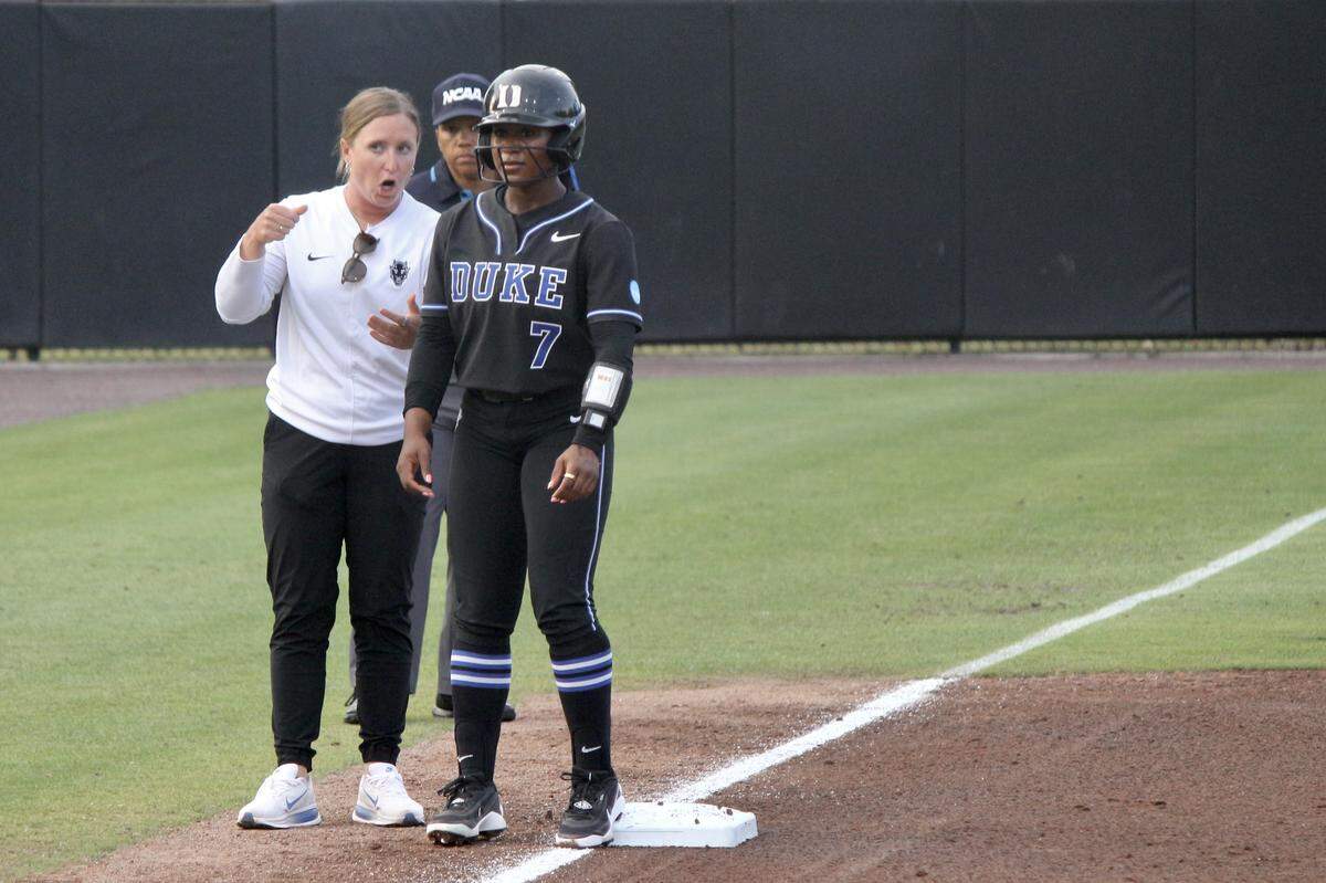 Duke outfielder Layla Lamar stands on third base while associate head coach Taylor Wikes provides instructions during the Blue Devils’ NCAA Tournament regional game against Marshall at Smith Family Stadium in Durham, NC, on May 16, 2026.