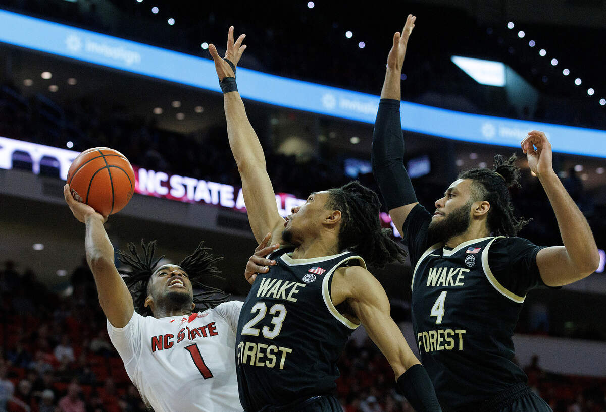 N.C. State’s Jayden Taylor shoots over Wake Forest’s Hunter Sallis and Efton Reid III late in the second half of the Wolfpack’s 83-76 win at PNC Arena on Tuesday, Jan. 16, 2024, in Raleigh, N.C.