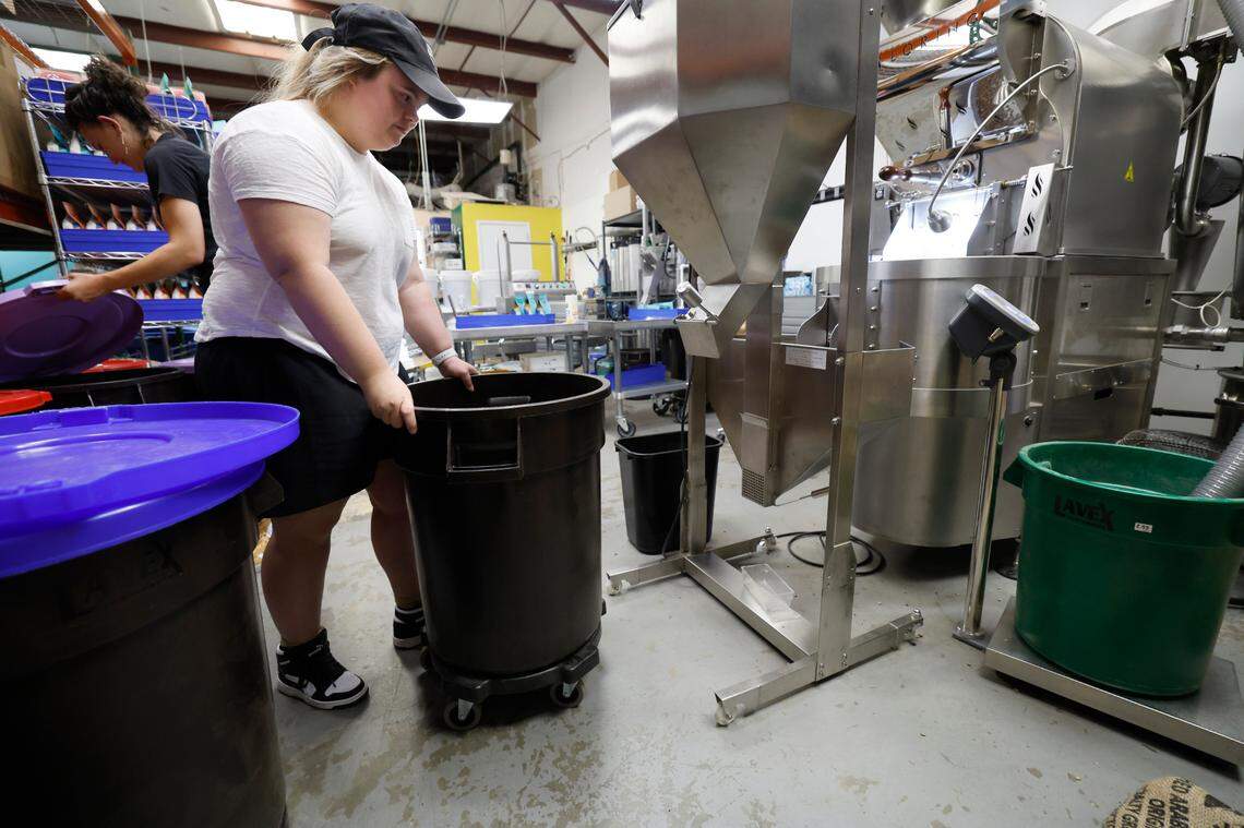 Sophie Pacyna wheels over a bin that stores the roasted coffee beans at the 321 Coffee roasting facility in Raleigh, N.C., Tuesday, June 25, 2024.