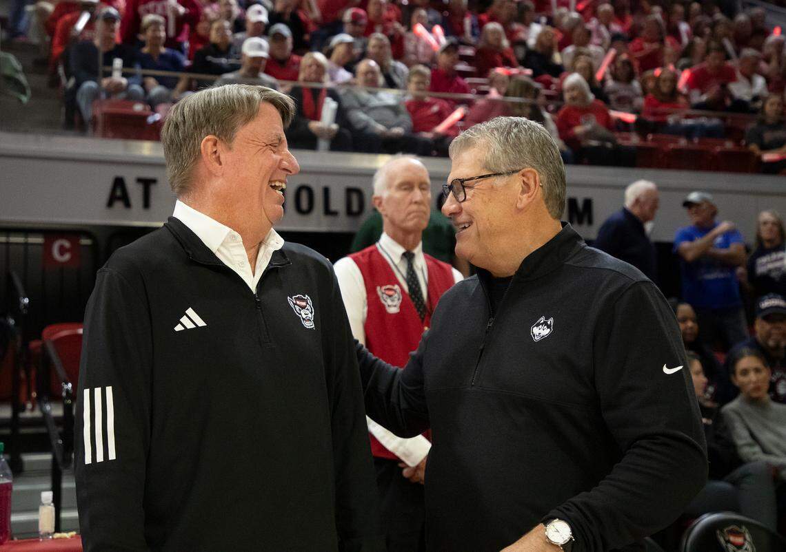 N.C. State head coach Wes Moore shares a laugh with UConn head coach Geno Auriemma prior to the Wolfpack’s game on Sunday, Nov. 12, 2023, at Reynolds Coliseum in Raleigh, N.C.