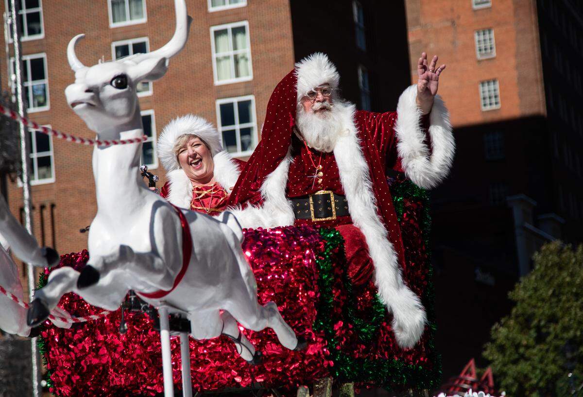 Santa Claus and Mrs. Claus wave to the crowd during Raleigh’s annual Christmas parade Nov. 17, 2018, on Fayetteville Street in downtown Raleigh. Tens of thousands of spectators line the 1.4-mile route with a curbside view of traditional marching bands, floats and costumed characters, mixed with a sampling of entries entirely unique to Raleigh.