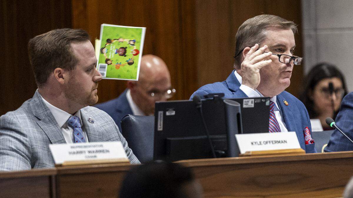 N.C. House Majority Leader Brenden Jones tosses the book “These Are My Eyes, This Is My Nose, This Is My Vulva, This Is My Toes” by Dr. Lexx Brown-James over his shoulder while questioning Chapel Hill-Carrboro City Schools Superintendent Rodney Trice and School Board Chair George Griffin during a sometimes tense House committee hearing on Wednesday, Dec. 10, 2025, in the Legislative Building auditorium in Raleigh. During the hearing, Jones cited and tossed several children’s books from a third-party list that had previously appeared on the district’s website.