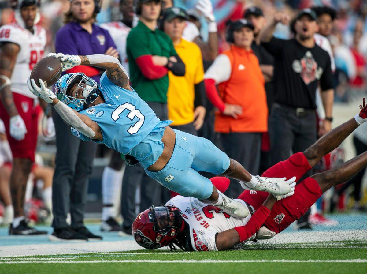 North Carolina’s Antonie Green (3) pulls in a pass from quarterback Drake Maye in the first quarter against N.C. State’s Aydan White (3) on Friday, November 25, 2022 at Kenan Stadium in Chapel Hill, N.C. Green could not control the catch.