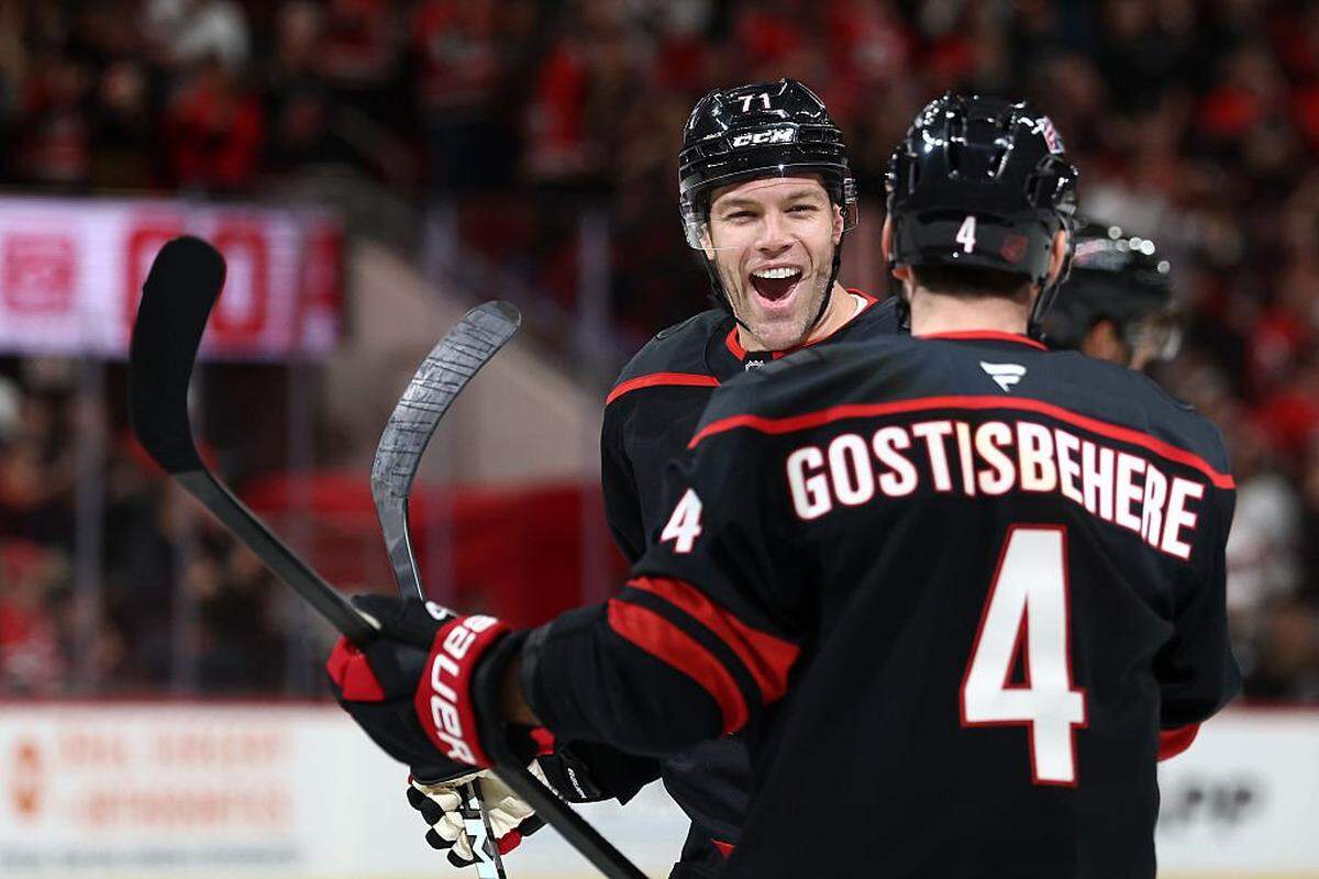 Taylor Hall of the Carolina Hurricanes celebrates with teammate Shayne Gostisbehere #4 following a goal scored during the first period of the game against the New Jersey Devils at Lenovo Center on October 09, 2025 in Raleigh, North Carolina.