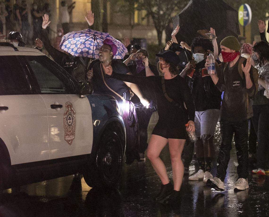 Protesters surround a Raleigh Police officer in his vehicle on Fayetteville Street on Friday, June 19, 2020 in Raleigh, N.C.