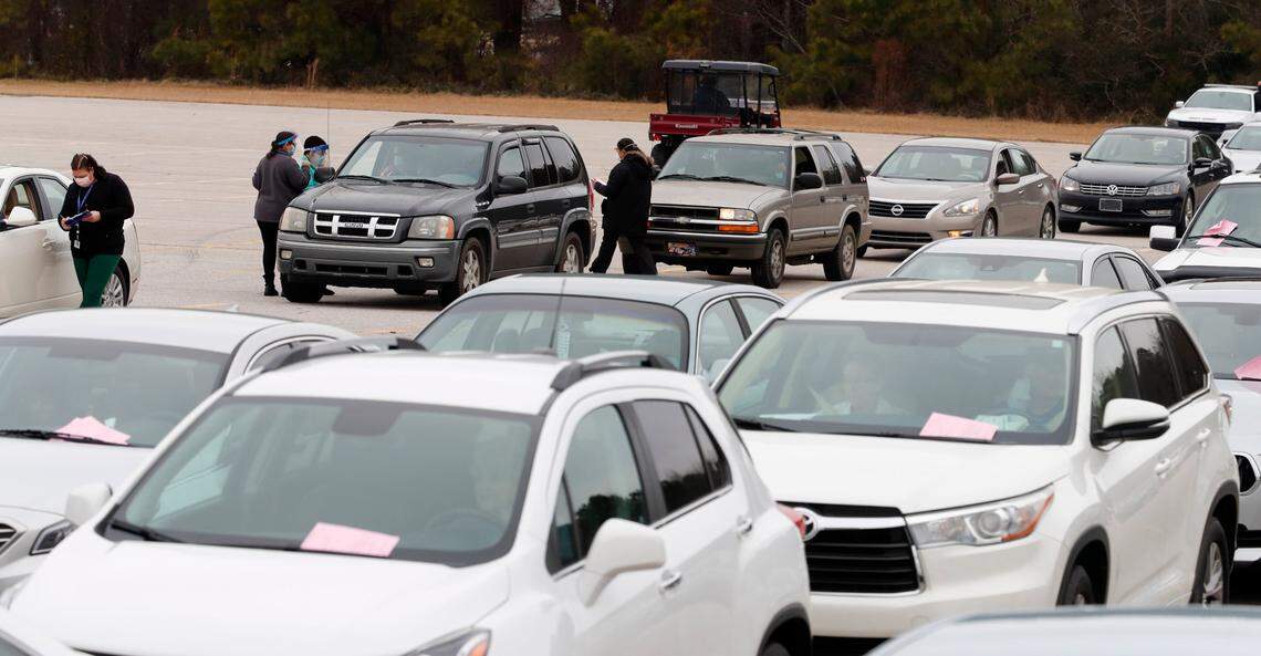 Registration information is collected from seniors lined up in their vehicles to get their COVID vaccine shot during a drive-thru COVID vaccination clinic at North Johnston High School in Kenly, N.C., Thursday, January 14, 2021.