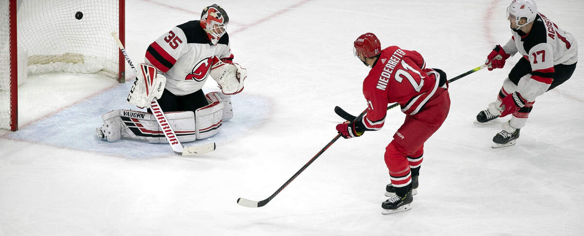 Carolina Hurricanes’ Nino Niederrelter (21) scores on New Jersey’s Cory Schneider (35) in the third period to give the Hurricanes’ as 3-1 victory and secure a playoff birth on Thursday, April 4, 2019 at the PNC Arena in Raleigh, N.C.