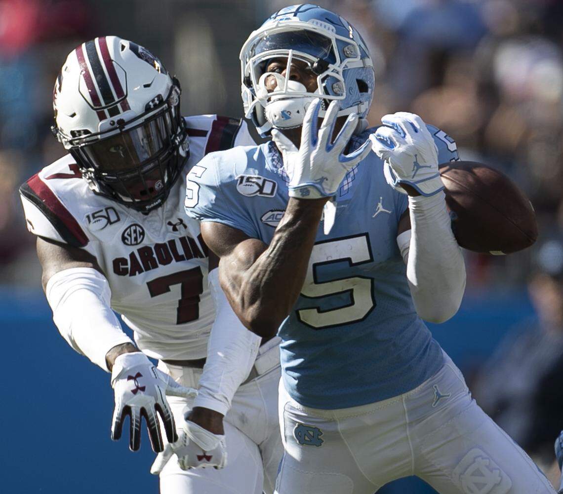 North Carolina’s Dazz Newsome (5) looses control of a long pass from quarterback Sam Howell (7) under defensive pressure from South Carolina’s Jammie Robinson (7) in the second quarter on Saturday, August 31, 2019 at Bank of America Stadium in Charlotte, N.C.