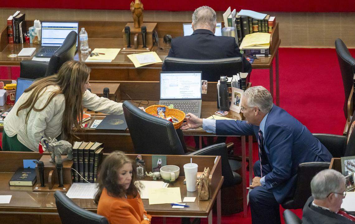 Rep. Tricia Cotham passes a bowl of candy to Rep. Kelly Hastings during debate of Senate Bill 249, legislation to realign the North Carolina Congressional districts, on Wednesday, October 22, 2025 at the General Assembly in Raleigh, N.C.