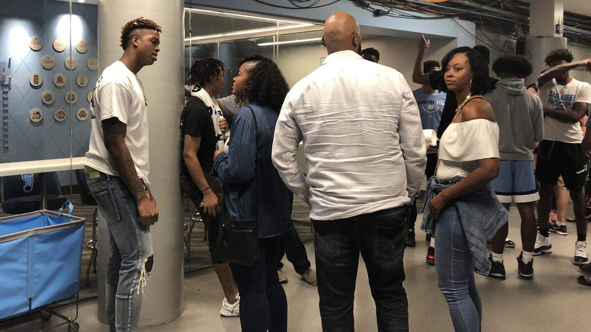 UNC commit Armando Bacot, left, talks to friends and family at the Dean Smith Center after the Hornets-Celtics preseason basketball game in October.