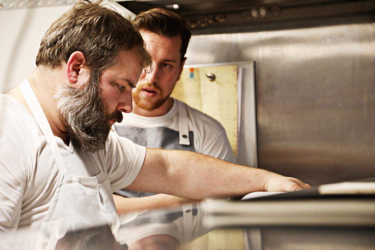 St. James owner and chef Matt Kelly, left, tinkers with a recipe alongside sous chef Glenn Osterberg, right, in the kitchen on January 8, 2020. The restaurant plans to reopen on Jan. 23, 2020, after being closed for several months after the Durham gas explosion last April.