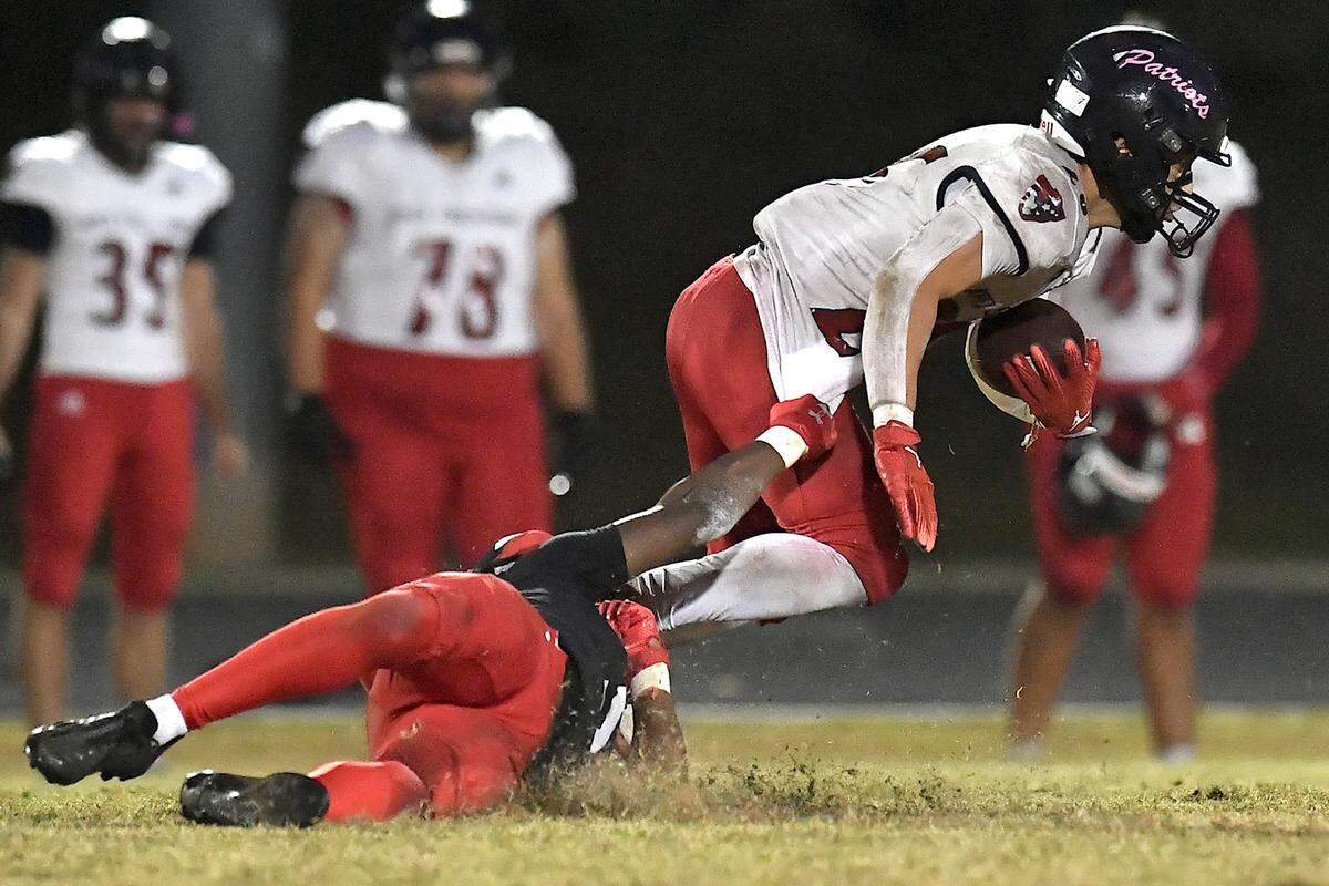 Middle Creek corner back Christian Prince (5) grapples Apex Friendship running back Jaden Avery (26) late in the fourth quarter. The Middle Creek Mustangs and the Apex Friendship Patriots met in a football game in Cary, N.C. on October 25, 2024.