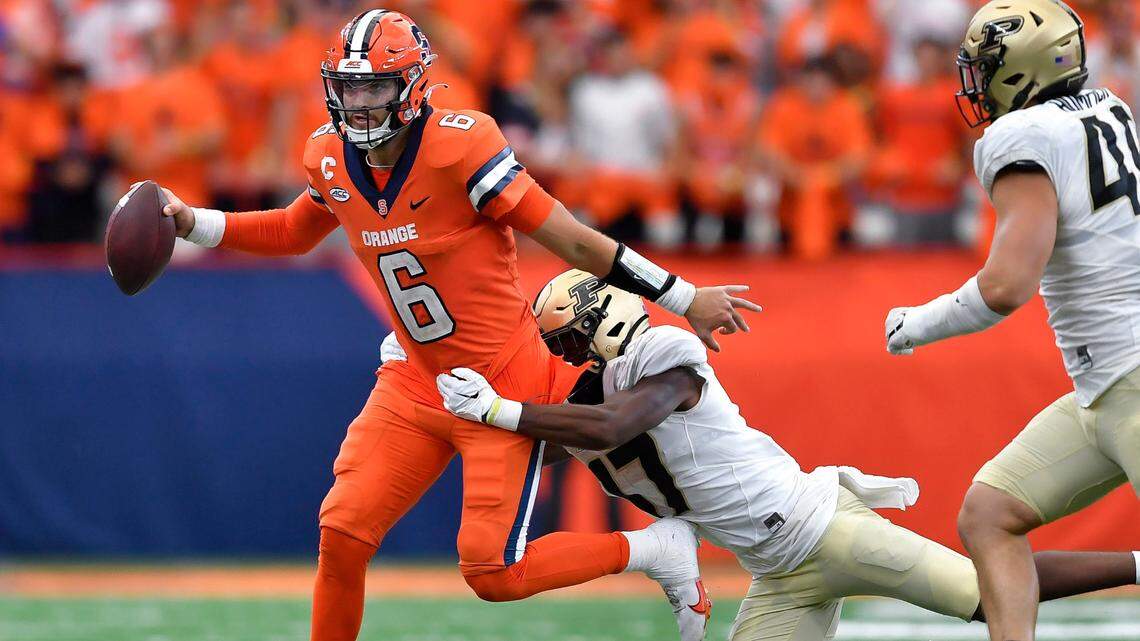 Syracuse quarterback Garrett Shrader, left, looks to throw while pressured by Purdue safety Chris Jefferson during the second half of an NCAA college football game in Syracuse, N.Y., Saturday, Sept. 17, 2022. Syracuse won 32-29.