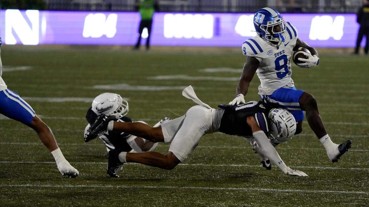 Sep 6, 2024; Evanston, Illinois, USA; Northwestern Wildcats defensive back Theran Johnson (10) tackles Duke Blue Devils running back Jaquez Moore (9) during the first half at Lanny and Sharon Martin Stadium.