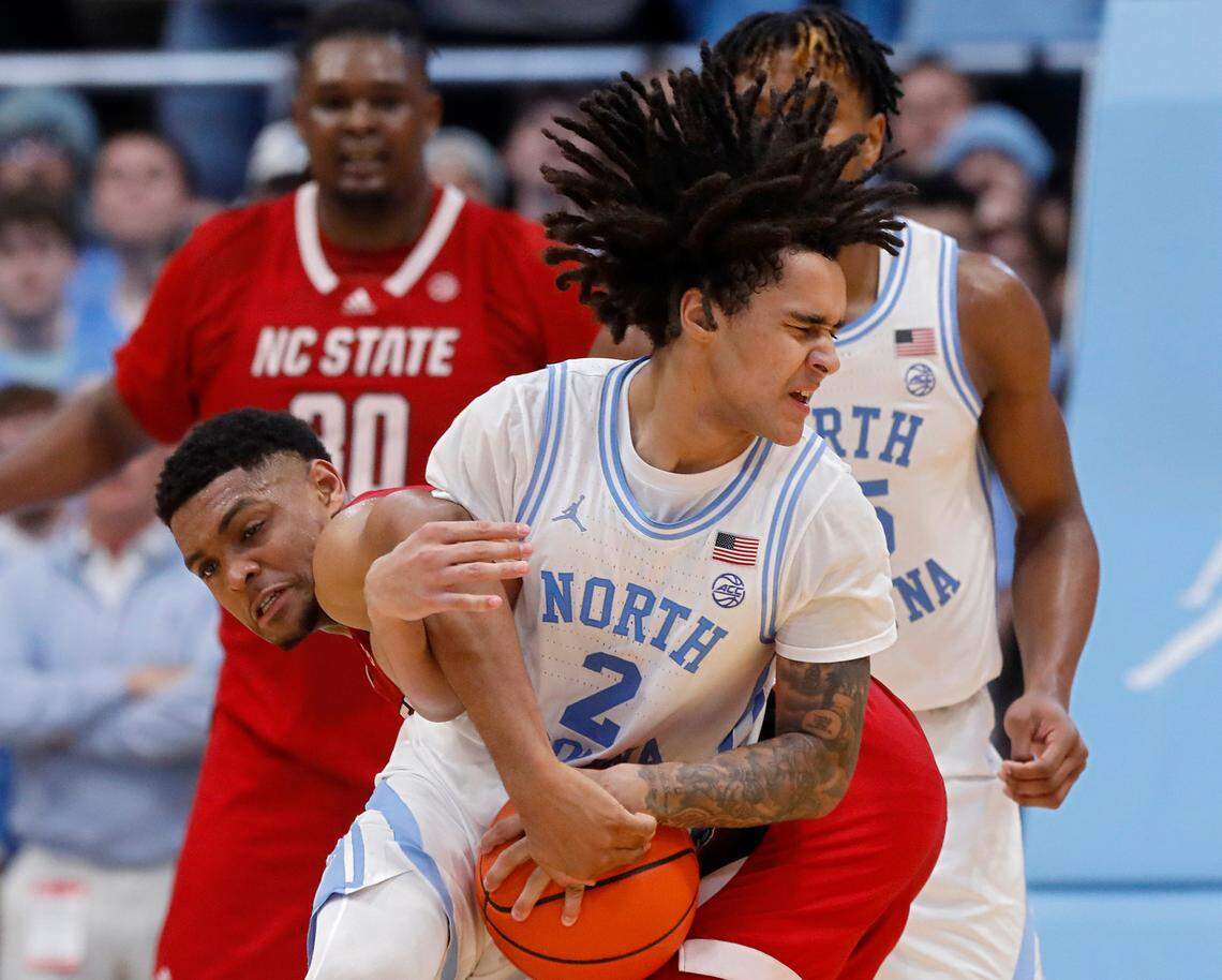 North Carolina’s Elliot Cadeau is fouled by N.C. State’s Casey Morsell during the second half of the Tar Heels’ 79-70 win on Saturday, March 2, 2024, at the Smith Center in Chapel Hill, N.C.