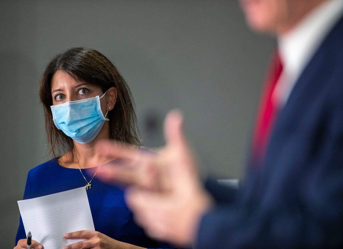 Dr. Mandy Cohen, Secretary of the North Carolina Department of Health and Human Services listens to North Carolina Governor Roy Cooper during a press briefing on the surge of COVID-19 cases on Thursday, September 9, 2021 at the Emergency Operations Center in Raleigh, N.C.
