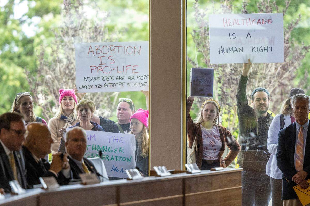 Demonstrators hold signs outside the legislature auditorium where a House Rules meeting&nbsp;was underway, May 3, 2023 at the Legislative Building. Republican state lawmakers announced their plan to limit abortion rights across the state.