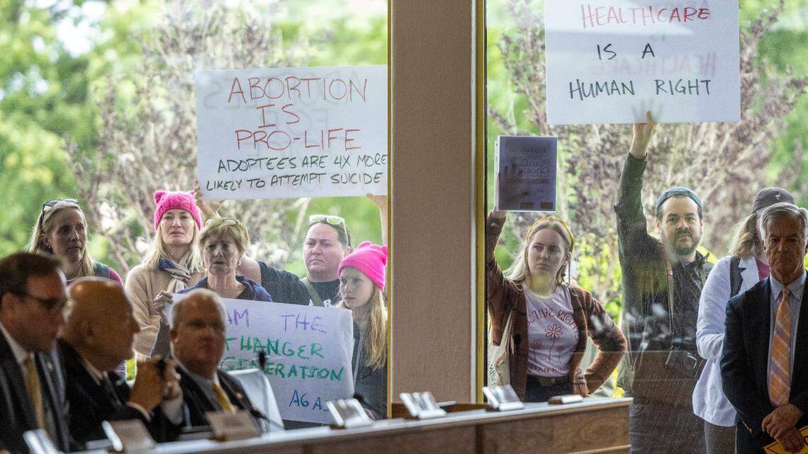 Demonstrators hold signs outside the legislature auditorium where a House Rules meeting was underway, May 3, 2023 at the Legislative Building. Republican state lawmakers announced their plan to limit abortion rights across the state.