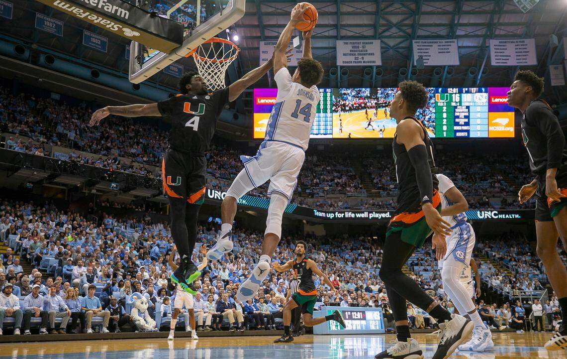 Miami’s Bensely Joseph (4) defends North Carolina’s Puff Johnson (14) in the first half on Monday, February 13, 2023 at the Smith Center in Chapel Hill, N.C.