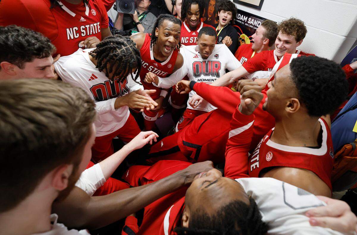 The Wolfpack players celebrate after putting their sticker on the wall after N.C. State’s 72-65 overtime victory over Virginia in the semifinals of the 2024 ACC Men’s Basketball Tournament at Capital One Arena in Washington, D.C., Friday, March 15, 2024.