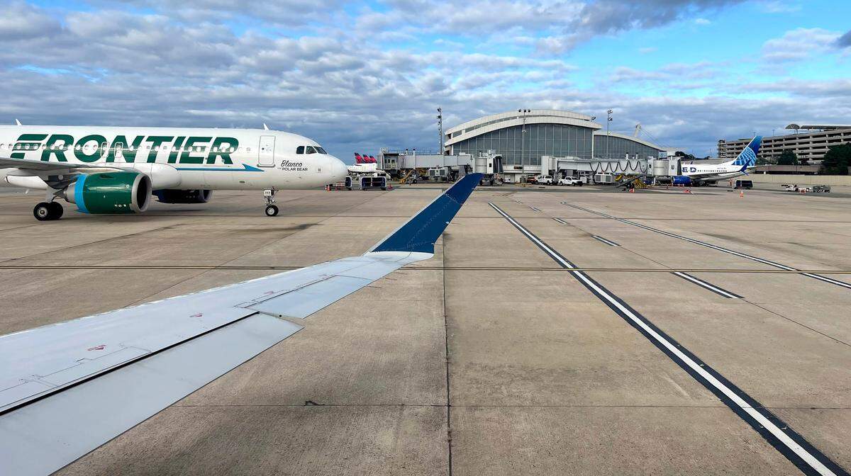 As a flight heads out to the runway, a Frontier flights heads towards its gate at Terminal 2 of Raleigh-Durham International Airport on Sept. 30, 2023.