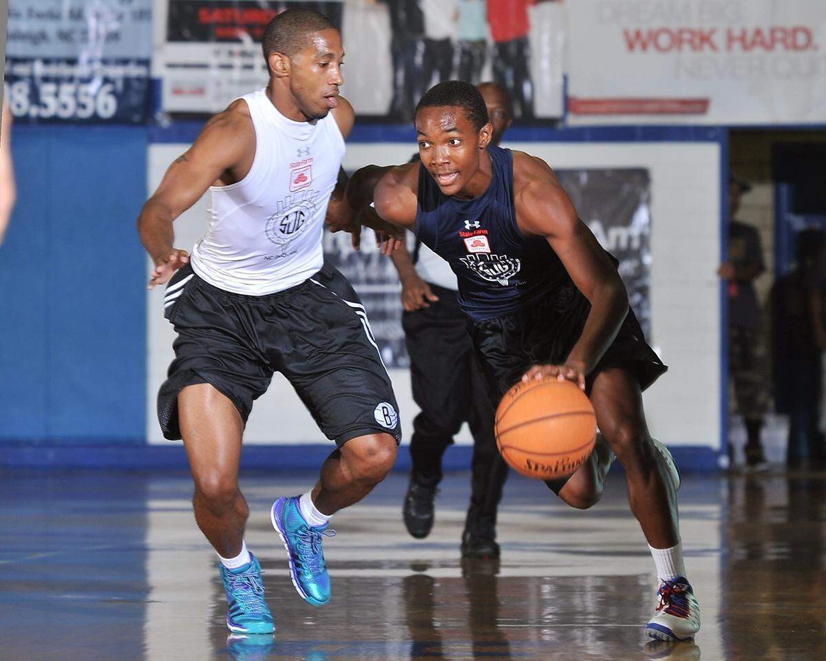 TLR's Devonte Graham (4) drives downcourt while defended by Dot's Marcus Wells (3) during a NC Pro-Am game in Durham in 2013.