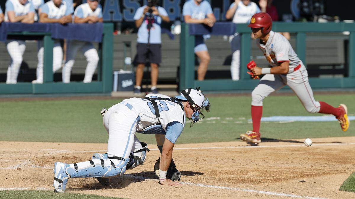 North Carolina's Colin Hynek (23) can’t get the ball as Southern California's Augie Lopez (24) scores in the seventh inning during UNC’s game against USC in the first game of the Chapel Hill Super Regional at Boshamer Stadium in Chapel Hill, N.C., Friday, June 5, 2026.