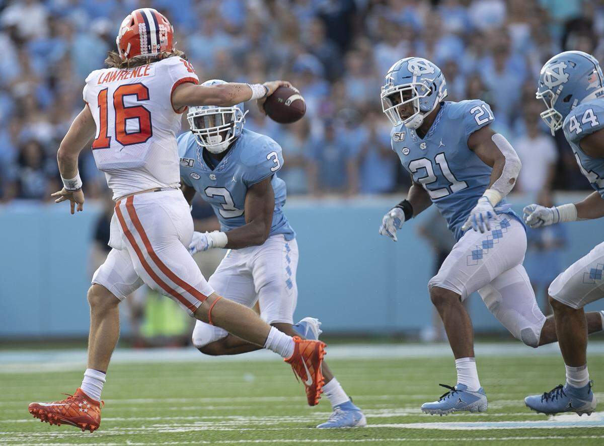 North Carolina linebackers Dominique Ross (3) Chazz Surratt (21) and Jeremiah Gemmell (44) pressure Clemson quarterback Trevor Lawrence (16) in the fourth quarter on Saturday, September 28, 2019 at Kenan Stadium in Chapel Hill, N.C.