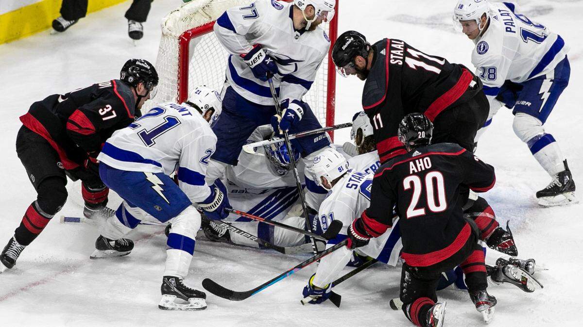 Carolina Hurricanes’ Andrei Svechnikov (37), Jordan Staal (11) and Sebastian Aho (20) frantically try to get a stick on the puck in the closing seconds of play in the third period as Tampa Bay goalie Andrei Vasilevskiy (88) secures the puck and a 2-1 victory on Tuesday, June 1, 2021 at PNC Arena in Raleigh, N.C. Vasilevskiy made 31 saves in the win.