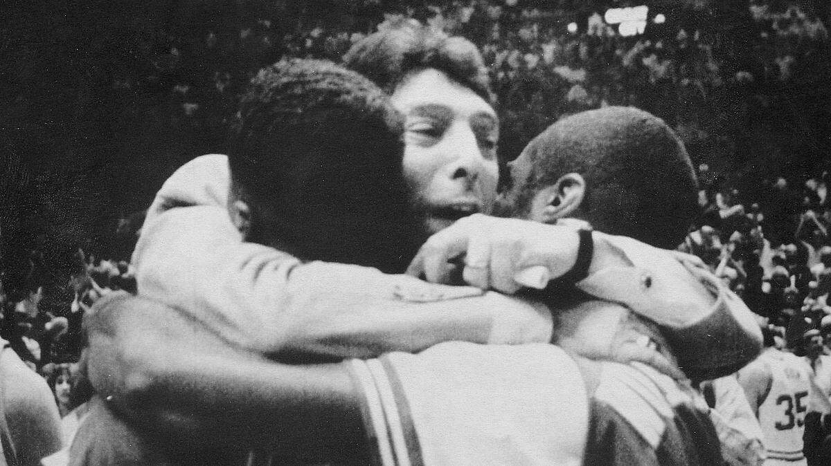 Former NC State coach Jim Valvano hugs two of his players after NCSU wins the ACC Tournament in 1987.