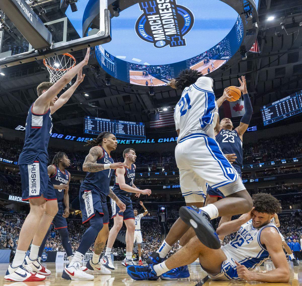 Duke forward Cameron Boozer (12) falls to the court after taking a hit in the face from Connecticut center Eric Reibe (12) in the first half on Sunday, March 29, 2026, in the NCAA East Regional Final, at Capital One Arena in Washington, D.C