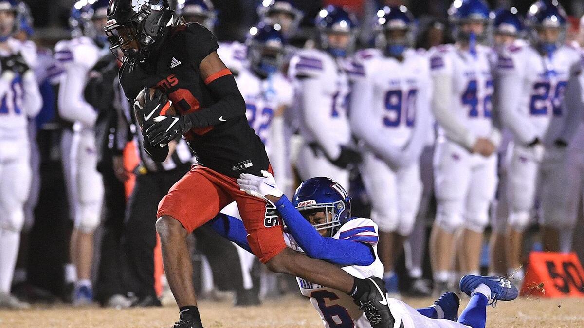 Rolesville’s Jayden Haynes (8) runs for the first down against Wake Forest’s Joshua Norris (6) during the first half. The Rolesville Rams and the Wake Forest Cougars met in the second round of the NCHSAA 4A Football Playoffs in Rolesville, N.C. on November 10, 2023.