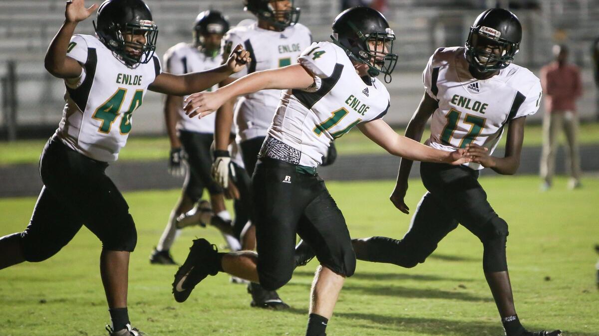 Enloe backup quarterback Jayden Morrison (14) celebrates with teammates Tyree Watson (40) and Jeremiah Jordan (17) after Morrison scored a late touchdown during the Enloe Eagles’ football game at the South Garner Titans on Monday, August 26, 2019. Enloe won the game 48-13.