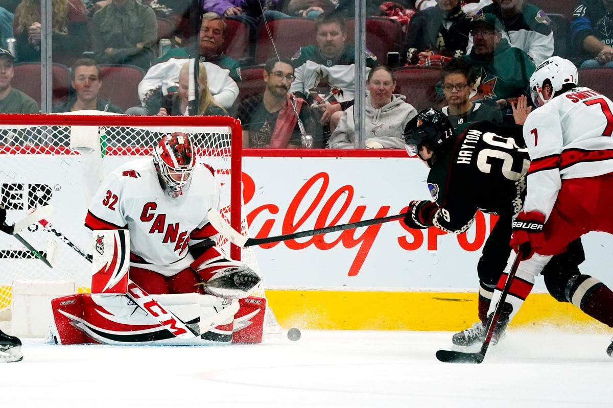 Carolina Hurricanes goaltender Antti Raanta (32) makes a save on a shot by Arizona Coyotes center Barrett Hayton (29) Hurricanes defenseman Brendan Smith (7) pressures the shot during the second period of an NHL hockey game Monday, April 18, 2022, in Glendale, Ariz. (AP Photo/Ross D. Franklin)