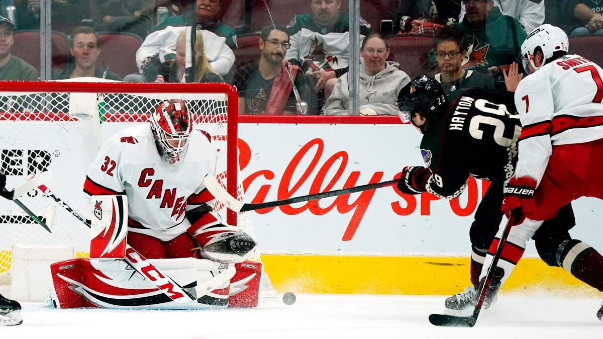 Carolina Hurricanes goaltender Antti Raanta (32) makes a save on a shot by Arizona Coyotes center Barrett Hayton (29) Hurricanes defenseman Brendan Smith (7) pressures the shot during the second period of an NHL hockey game Monday, April 18, 2022, in Glendale, Ariz. (AP Photo/Ross D. Franklin)