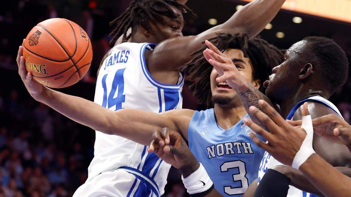 North Carolina’s Elliot Cadeau (3) drives between the defense of Duke’s Sion James (14) and Khaman Maluach (9) during the first half of Duke’s game against UNC in the semifinals of the 2025 ACC Men’s Basketball Tournament at the Spectrum Center in Charlotte, N.C., Friday, March 14, 2025.