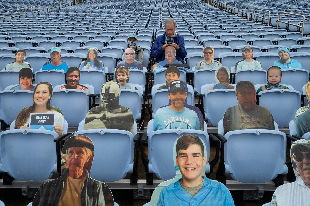 Charles Gainey of Clinton, N.C. and his grandson Graham Hardison of Apex, N.C. watch the Tar Heels’ warm up for their game against Virginia Tech on Saturday, October 10, 2020 at Kenan Stadium in Chapel Hill, N.C. Under new COVID-19 guidelines 3500 people were allowed into the stadium for the game Saturday.