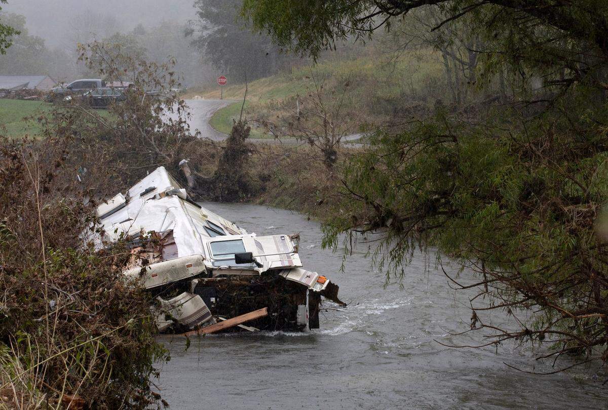 An overturned camper van sits in Big Horse Creek in Lansing, N.C. following Hurricane Helene on Monday, Sept. 30, 2024.